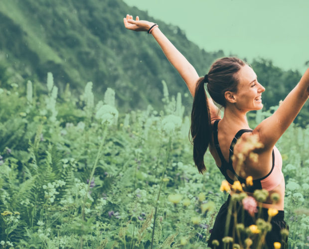 Joyful woman enjoying freedom on lush green grass